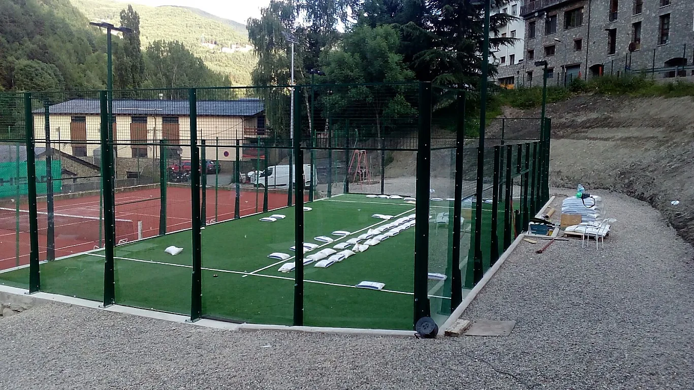 Pista de pádel con césped verde y cerramientos de cristal en Andorra